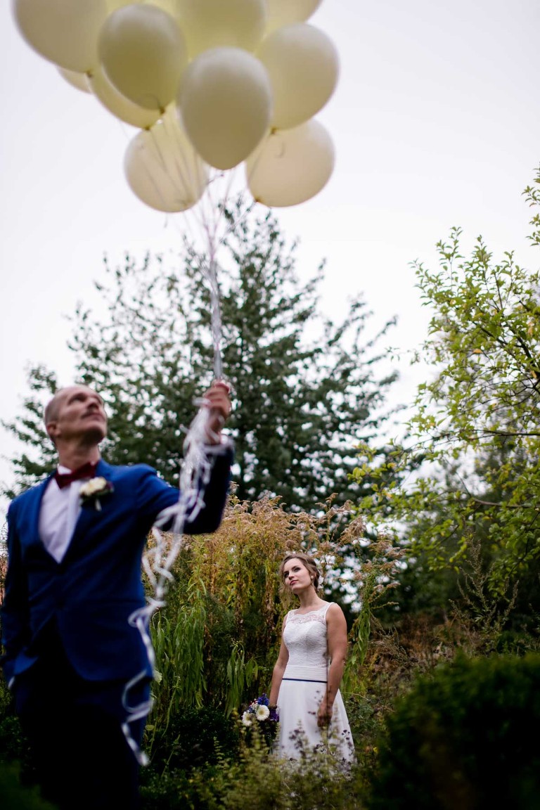 Hipster-Bräutigam hält Ballons und moderne Braut fotografiert vom Hochzeitsfotograf in Dresden