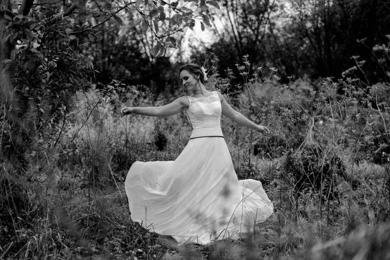 Hübsche junge Braut tanzt beim Paarshooting