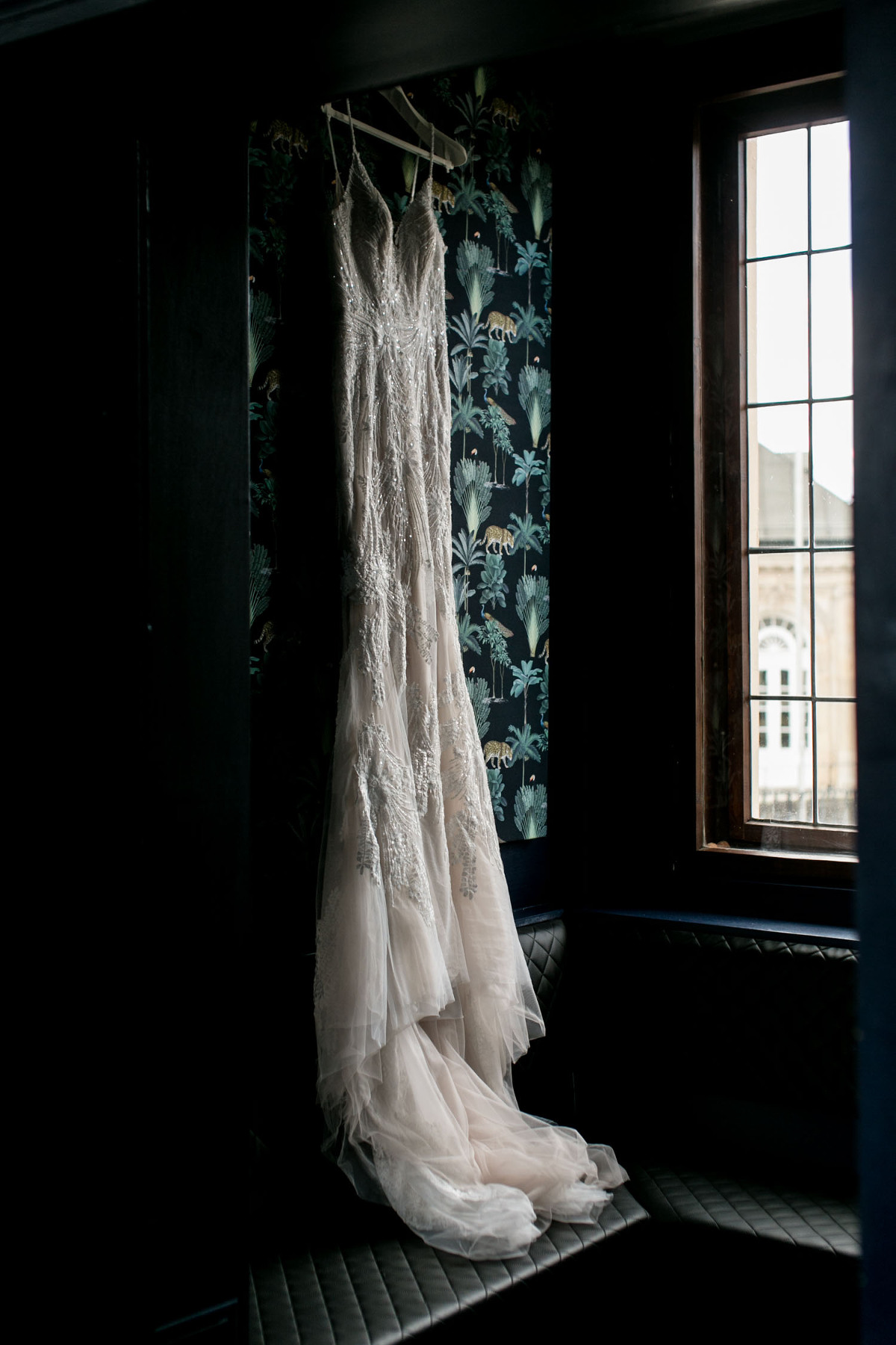 Brautkleid beim Getting ready hängt am Fenster