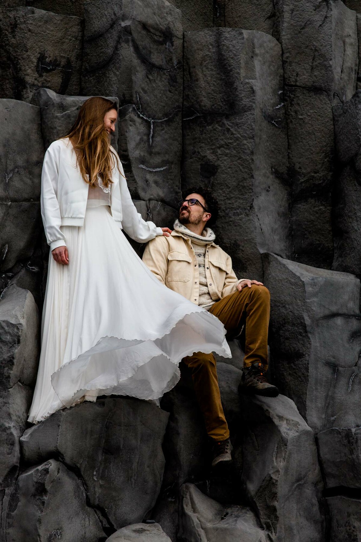 Brautpaar sitzt in den Basaltformationen in Vik